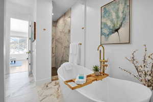 Full bathroom with a marble finish shower, marble finish floors, a freestanding bath, and recessed lighting