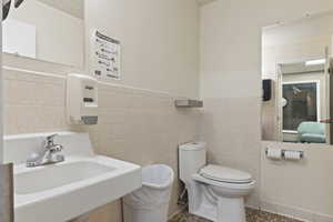 Bathroom featuring wainscoting and tile walls