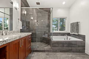 Bathroom featuring a garden tub, vanity, healthy amount of natural light, and a shower stall