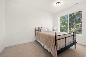 Bedroom with baseboards and light carpet