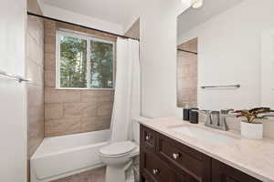 Bathroom featuring vanity and shower / bathtub combination with curtain