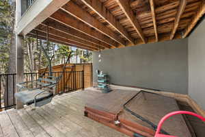 Wooden terrace featuring a covered hot tub
