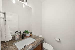 Half bathroom with vanity and toilet