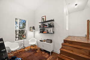 Sitting room featuring dark wood-style floors and lofted ceiling
