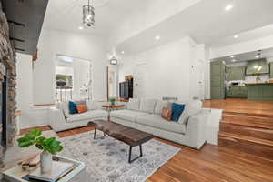 Living area featuring a fireplace, light wood finished floors, lofted ceiling, and recessed lighting