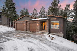 View of front of house featuring an attached garage and stone siding