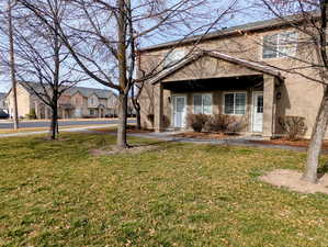 View of front facade featuring a front yard, stucco siding, and a residential view