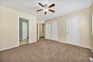 Unfurnished bedroom featuring carpet flooring, ceiling fan, and a closet