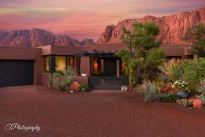 Adobe home with a mountain view, stucco siding, driveway, and an attached garage