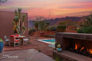 View of swimming pool featuring outdoor dining space, patio surround, a mountain view, and a fenced backyard