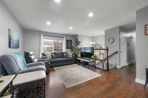 Living room with a chandelier and dark wood-type flooring