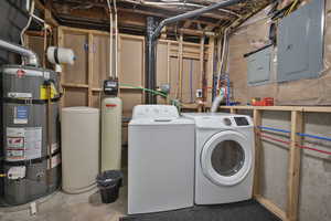 Laundry area featuring electric panel, unfinished concrete flooring, water heater, and washing machine and clothes dryer