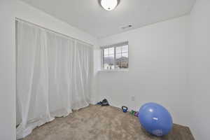 Exercise room with carpet flooring and a textured ceiling