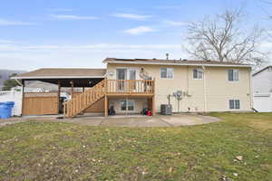 Rear view of property featuring a patio, a deck, and solar panels