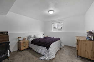 Bedroom featuring carpet flooring and a textured ceiling