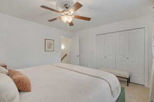 Bedroom featuring ceiling fan, a closet, and carpet floors