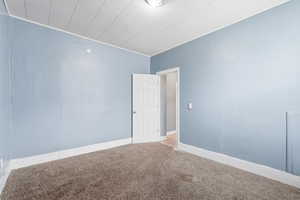 Empty room with carpet and baseboards