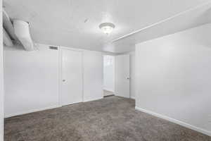 Unfurnished bedroom with carpet and a textured ceiling