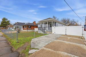 Bungalow featuring a gate, a porch, and a fenced front yard