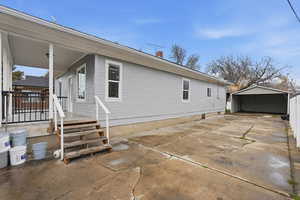 View of side of property driveway, a patio area, and a detached carport