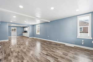 Unfurnished living room featuring recessed lighting.