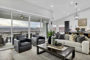 Living area with a mountain view, recessed lighting, light wood-type flooring, vaulted ceiling, and ceiling fan