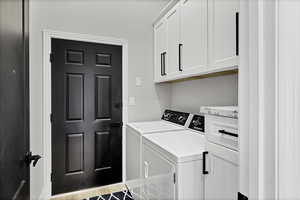 Laundry area with cabinet space and washing machine and dryer