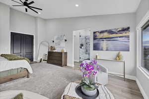 Bedroom featuring wood finished floors, ensuite bathroom, a ceiling fan, recessed lighting, and a closet