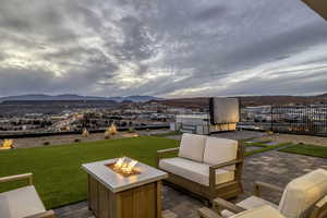 Wooden deck with a patio, a mountain view, a yard, and an outdoor living space with a fire pit