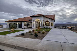 Mediterranean / spanish home with a tiled roof, a mountain view, driveway, and stucco siding