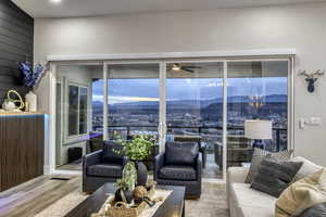 Living room with a mountain view, wood finished floors, and a ceiling fan