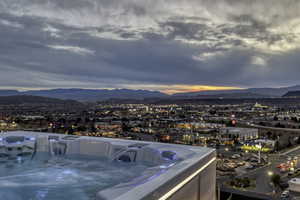 Balcony featuring a mountain view, a hot tub, and a city view
