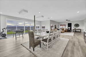 Dining space featuring a mountain view, light wood-type flooring, a ceiling fan, and recessed lighting