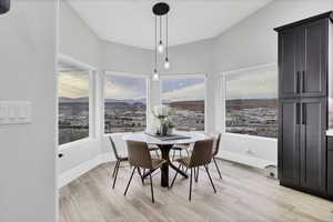 Dining area with a mountain view, light wood finished floors, and plenty of natural light