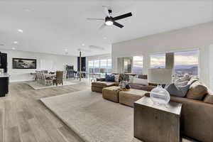 Living room with light wood-style flooring and ceiling fan