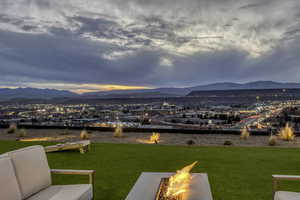 Yard at dusk featuring an outdoor fire pit, a mountain view, a yard, and a patio area