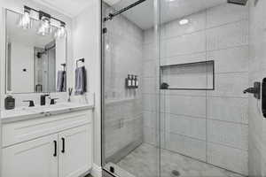 Bathroom featuring a shower stall and vanity