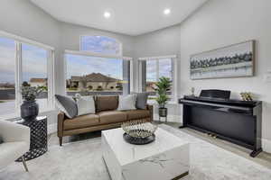 Living room with light wood-type flooring and recessed lighting