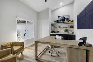 Office area with light wood finished floors and recessed lighting