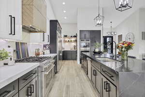 Kitchen featuring stainless steel appliances, dark stone countertops, a large island, and light wood-type flooring