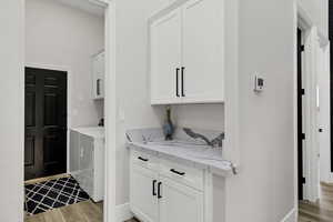 Laundry area with light wood finished floors, independent washer and dryer, and cabinet space