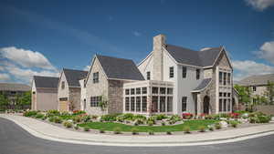 View of property exterior featuring stone siding, roof with shingles, and a chimney