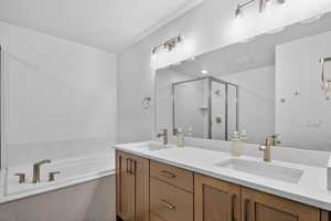 Bathroom with a shower stall, double vanity, and a garden tub