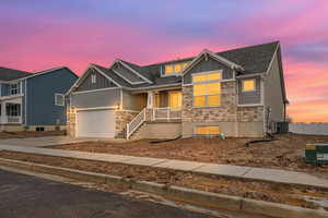 Craftsman-style home with stone siding, board and batten siding, a porch, and concrete driveway