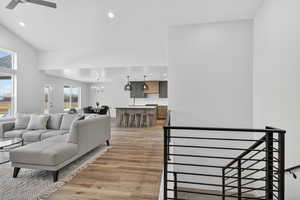 Living area featuring light wood finished floors, a ceiling fan, and suspended lighting