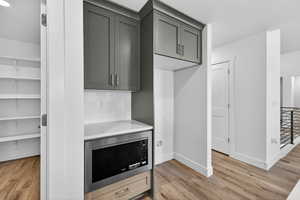 Kitchen featuring stainless steel microwave and light wood finished floors