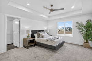 Bedroom featuring carpet floors, a ceiling fan, recessed lighting, and a raised ceiling