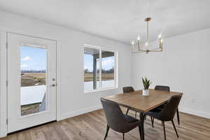 Dining area with light wood finished floors and a chandelier