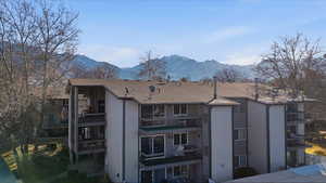 Back of property with a mountain view and stucco siding