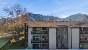 Back of house featuring a mountain view, a balcony, and stucco siding